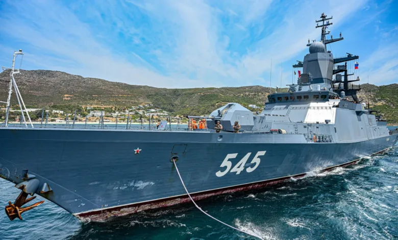 Russian Navy corvette "Stoikiy" (545) underway, docked near mountains under a blue sky.