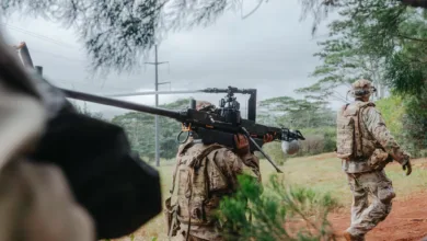 Soldier carries a weapon system on his shoulder during training exercise.