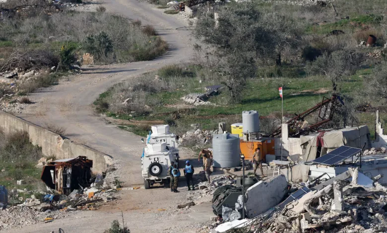 UNIFIL peacekeepers in damaged area with vehicle and equipment.