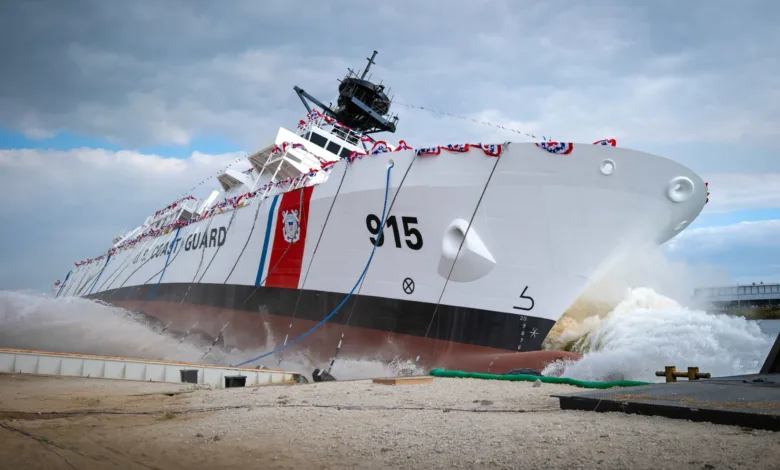 US Coast Guard cutter launching, hull number 915, with water splashing.