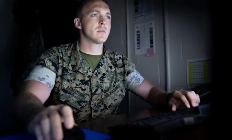 US Marine in uniform working on computer at night.