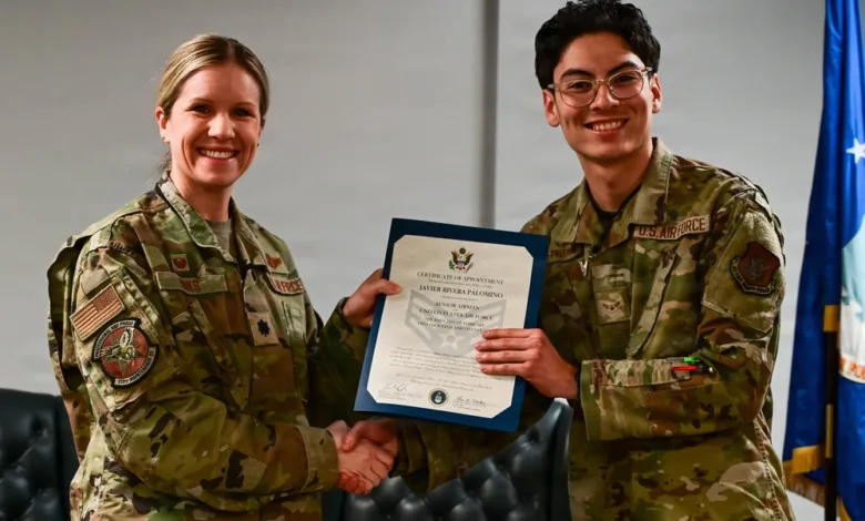 Air Force officer shaking hands, presenting certificate to Airman Palomino.