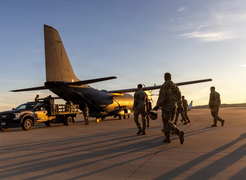 Air Force personnel and plane at sunset; Operation Ghost Rig exercise. Tail number 27724 visible.