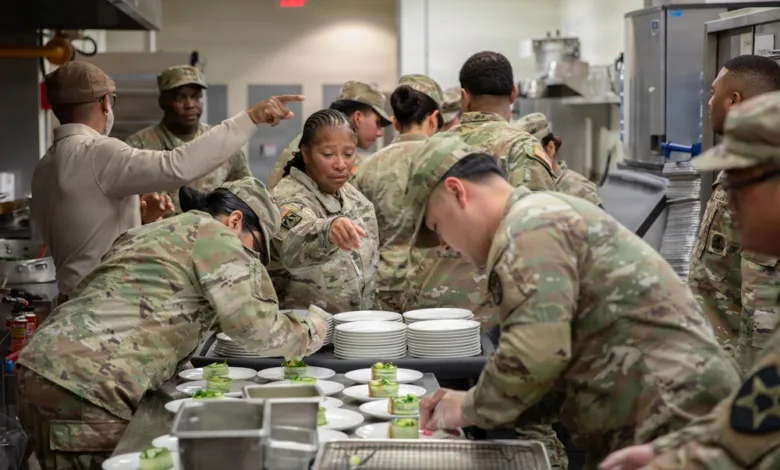 Army cooks preparing food in a kitchen, plates with appetizers.