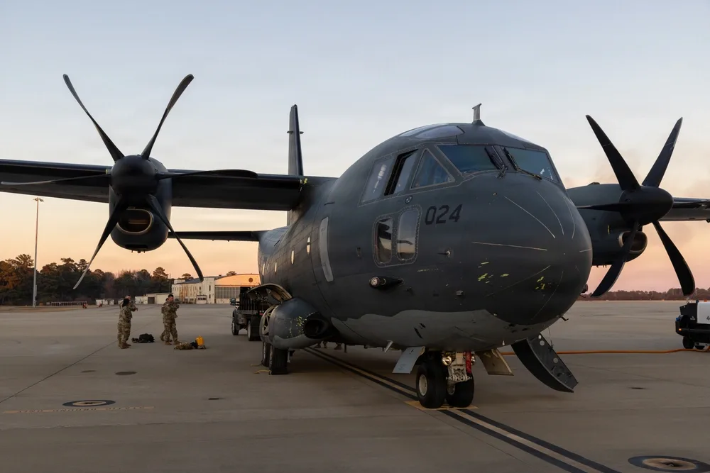 C-27J Spartan aircraft on tarmac with 3rd Special Forces Group personnel nearby.
