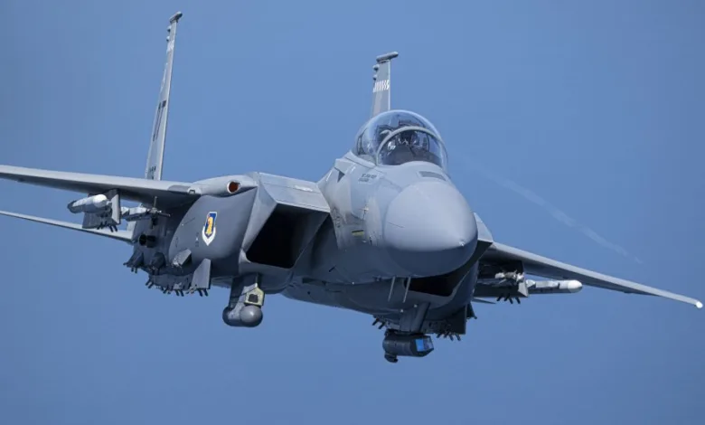 F-15EX fighter jet in flight against a blue sky, Kadena Air Base deployment.