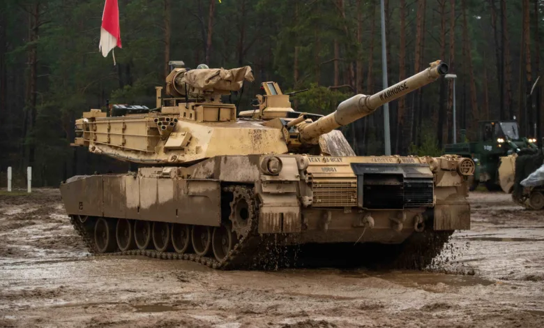 M1 Abrams tank "WARHORSE" in muddy field during winter training in Poland.