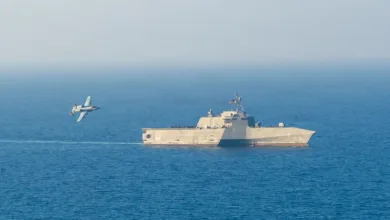 Littoral Combat Ship with A-10 Thunderbolt II flying nearby on the ocean.