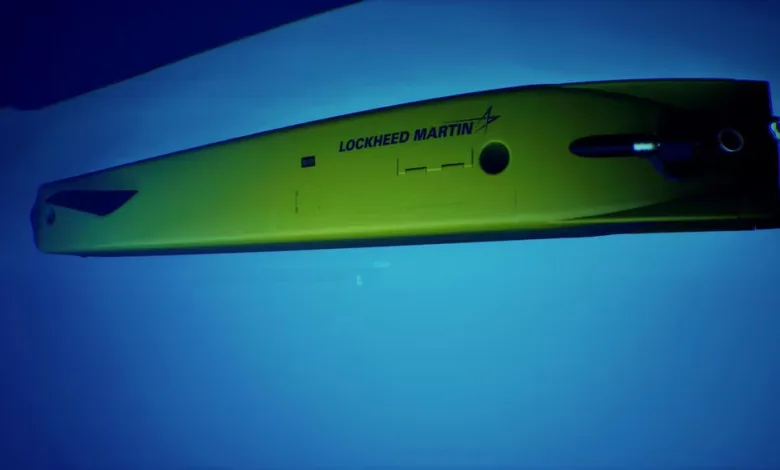 Lockheed Martin autonomous underwater vehicle (AUV) in water. Yellow submarine with black accents.
