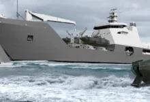 Military landing craft deploying vehicles onto a beach, with a Humvee exiting the larger vessel.