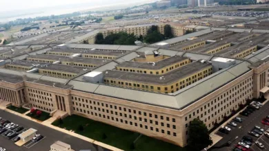 Aerial view of The Pentagon building in Arlington, Virginia, with parking lots and surrounding greenery visible.