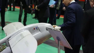 Putin examines a grey unmanned aerial vehicle (UAV) at an exhibition.