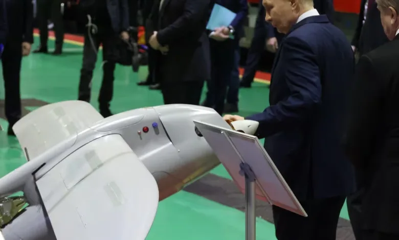 Putin examines a grey unmanned aerial vehicle (UAV) at an exhibition.