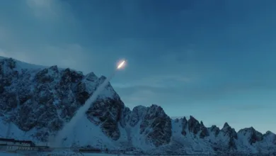 Rocket launch against snowy mountains and blue sky.