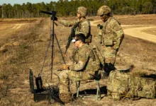 Soldiers using drone technology in field training exercise with tripod and gear.