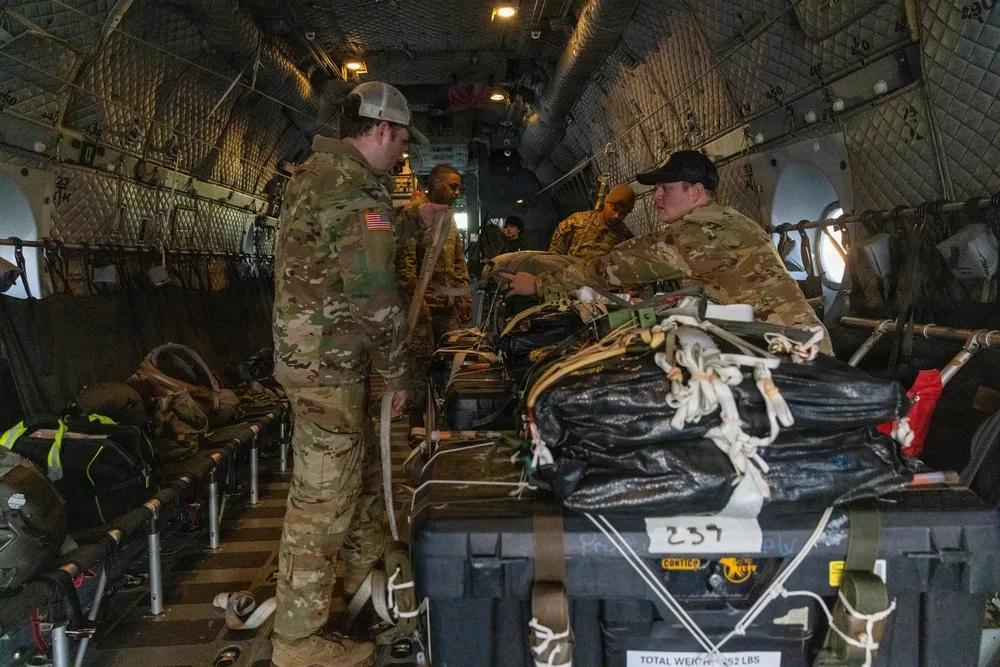 Soldiers rigging equipment inside aircraft, prepping for Exercise Operation Ghost Rig.
