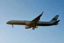 United States Air Force Boeing C-32 aircraft with landing gear down against a clear blue sky.