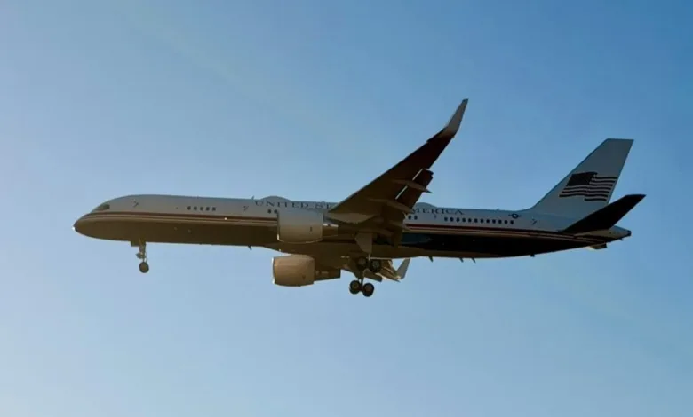 United States Air Force Boeing C-32 aircraft with landing gear down against a clear blue sky.