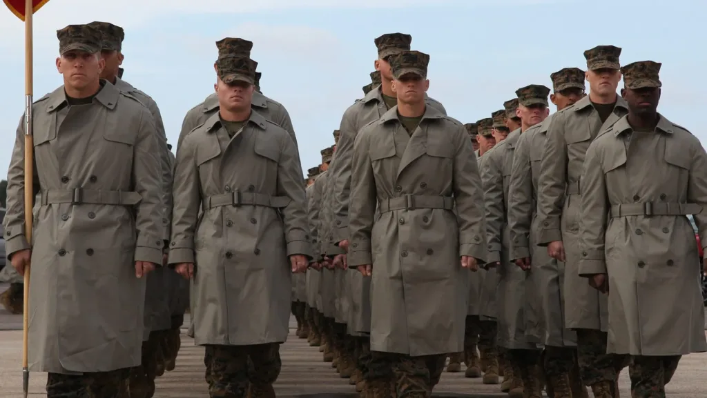 US Marines in formation wearing trench coats and campaign hats.