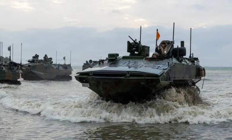 Amphibious assault vehicles emerging from the sea during military exercise.