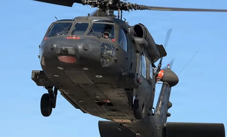 Black Hawk helicopter in flight against a blue sky background.