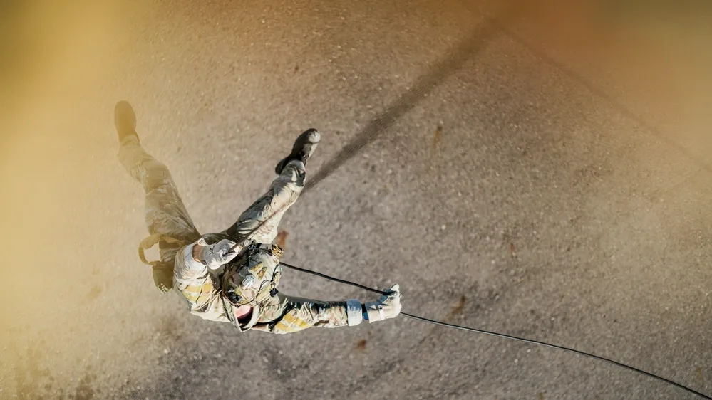 EOD technician rappels down a building during daytime training exercise.