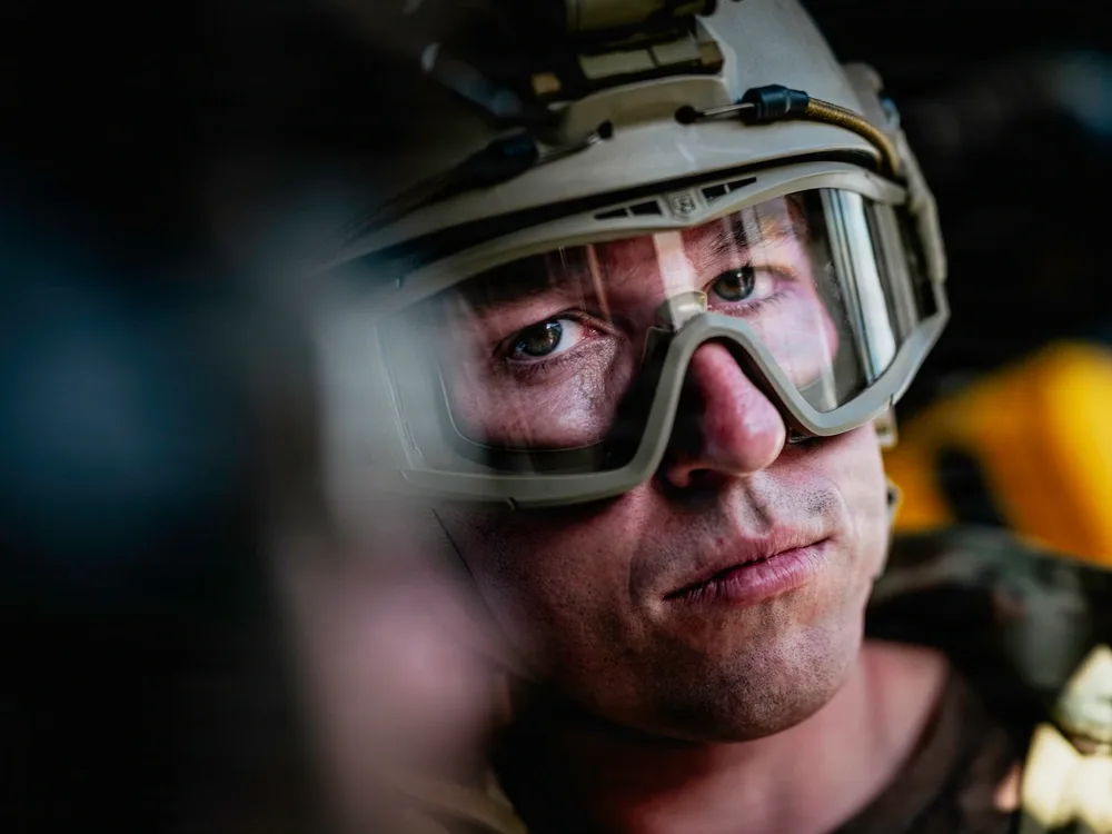 Close-up of EOD technician in helmet and goggles, focused expression.