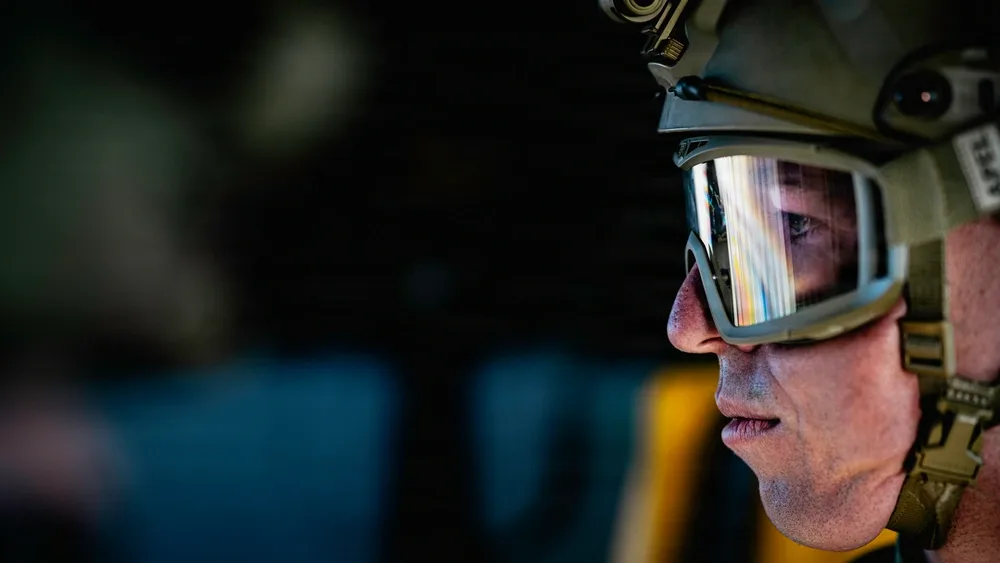 EOD technician wearing helmet and goggles, rappelling practice, eye reflection.