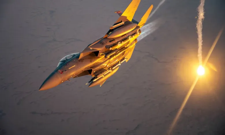 F-15 Eagle fighter jet deploying flares against a desert backdrop, golden hour lighting.