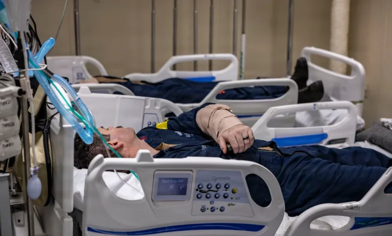 Injured sailor in hospital bed, USS Iwo Jima training support. Bandaged arm, medical equipment.