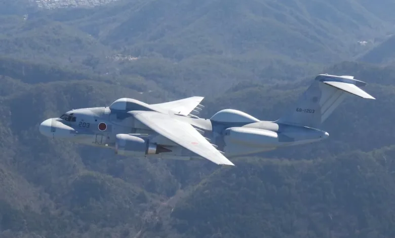 Japanese Kawasaki C-2 military transport aircraft flying over mountainous terrain. Tail number 68-1203 visible.