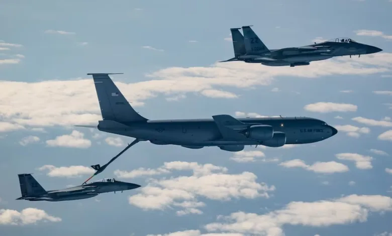 US Air Force KC-135 Stratotanker refueling F-15 Eagle fighter jets mid-air against a cloudy sky.