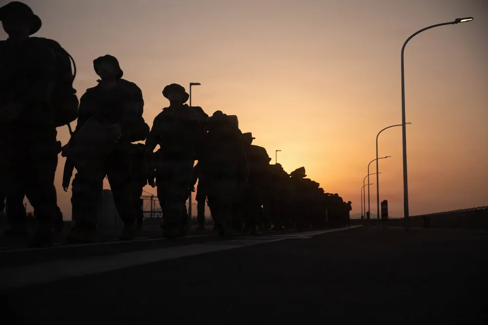 Silhouetted Marines hike at sunset. MCAS Iwakuni HHS supply hike.