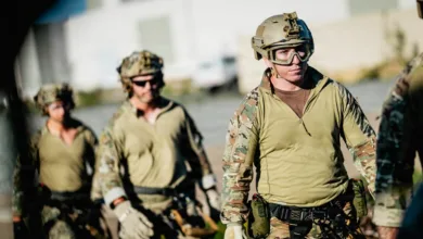 Military team in tactical gear, preparing for action in an outdoor setting.