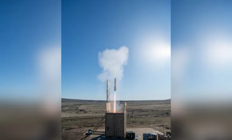 Missile launching from container with smoke plume against blue sky. Defense technology.