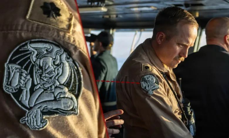 Navy officer with gargoyle patch on uniform sleeve.