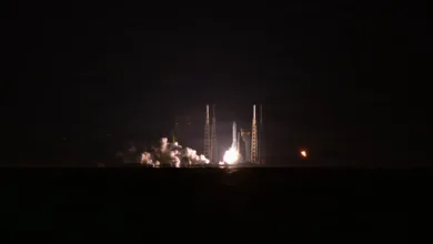 Rocket launch at night with bright flames and smoke.