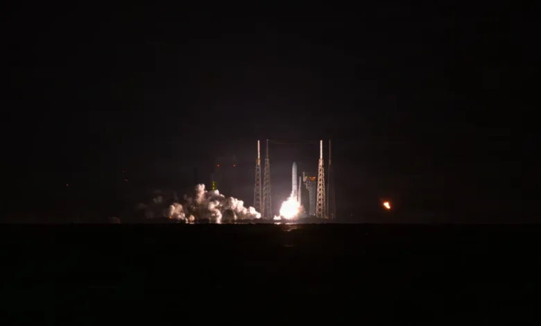 Rocket launch at night with bright flames and smoke.