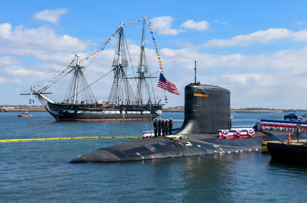 USS Constitution tall ship and submarine in Boston harbor. US Navy vessels.