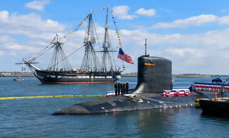 USS Constitution tall ship and submarine in Boston harbor. US Navy vessels.