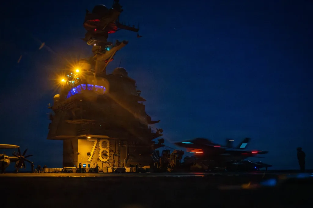 Night shot of USS Gerald R. Ford (CVN-78) with F-35C Lightning II aircraft on deck.