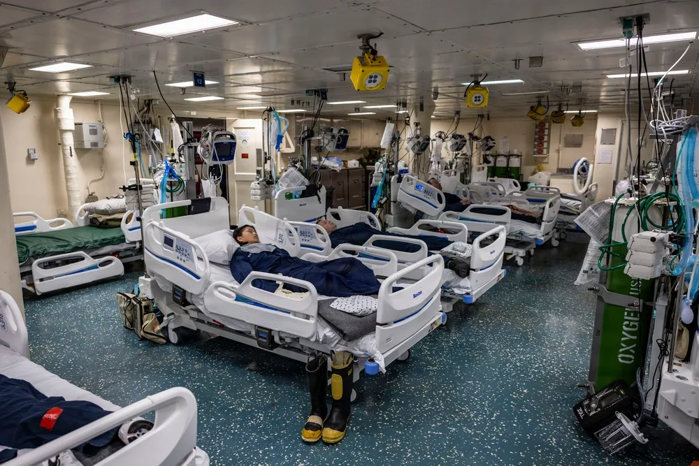 USS Iwo Jima: Patients in a medical bay with beds and equipment.