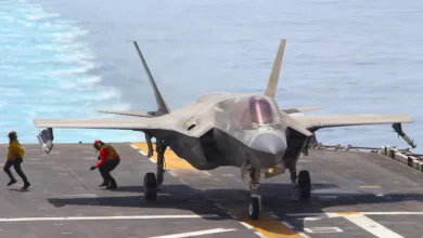 F-35 fighter jet on aircraft carrier deck with crew