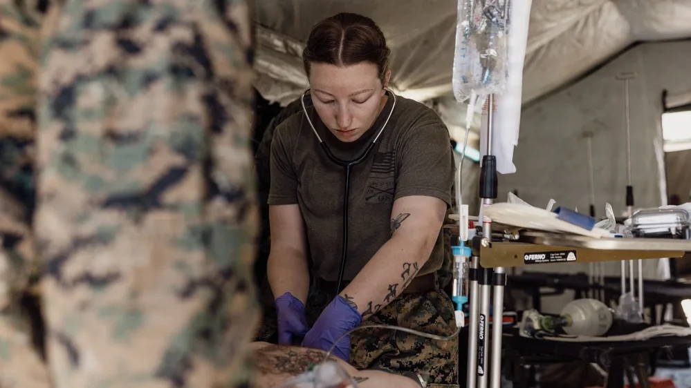Marine medic treats casualty during evacuation training exercise.