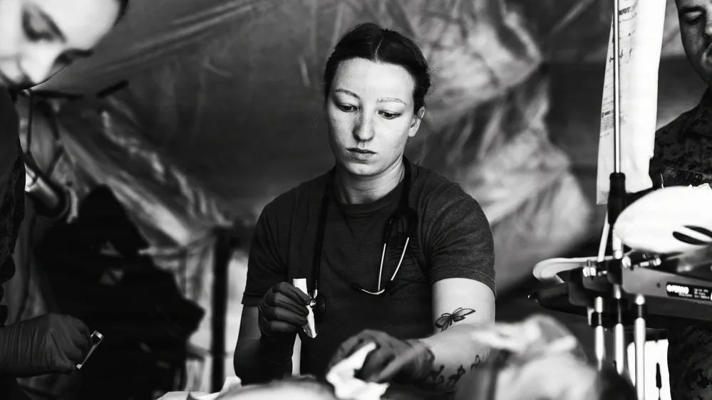 Medic treating patient during simulated casualty evacuation training exercise.