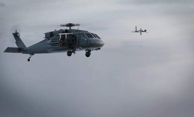 Military helicopter firing missile at drone in flight, gray sky background.