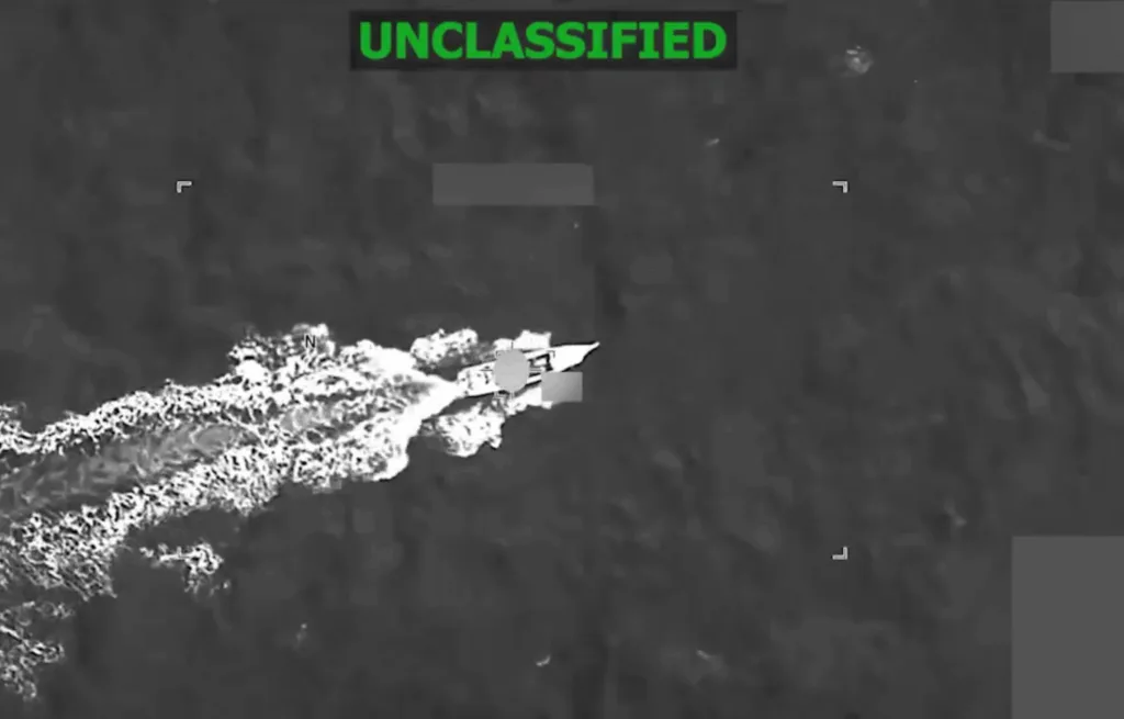 Unclassified aerial view of a naval vessel leaving a white wake.