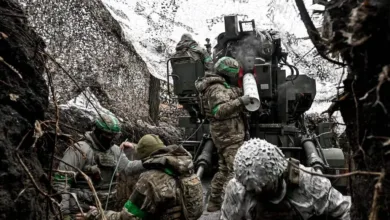 Ukrainian soldiers operating anti-aircraft gun in camouflage, possibly near the front lines.