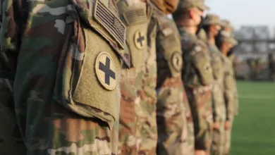 US Army soldiers in formation wearing camouflage uniforms and patches.