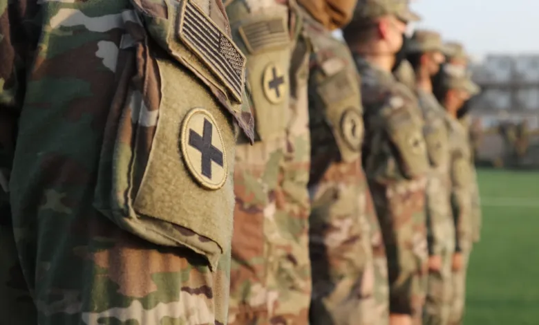 US Army soldiers in formation wearing camouflage uniforms and patches.